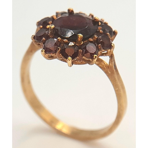 1142 - An 18K Yellow Gold Garnet Floral Cluster Ring. Size P, 3.69g total weight.