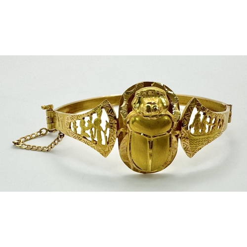 118 - A fine 18 K yellow gold “Egyptian Revival” bangle with a three-dimensional scarab and Tutankhamun’s ... 