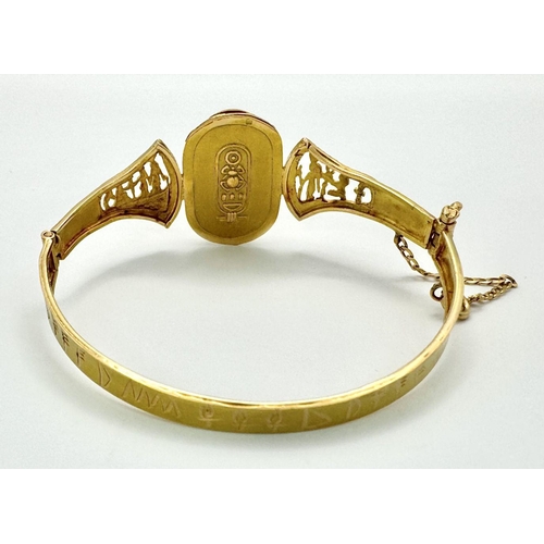 118 - A fine 18 K yellow gold “Egyptian Revival” bangle with a three-dimensional scarab and Tutankhamun’s ... 