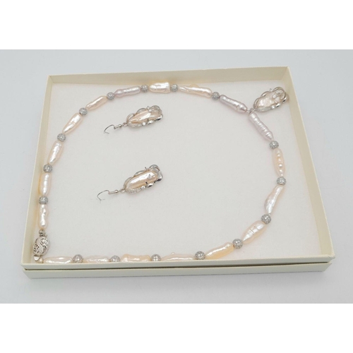 188 - A very elegant and attractive pearl necklace and earrings set in a presentation box. The elongated c... 