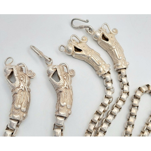 244 - A “Tibetan silver” necklace and bracelet set with double Chinese Dragon head clasps. In a presentati... 