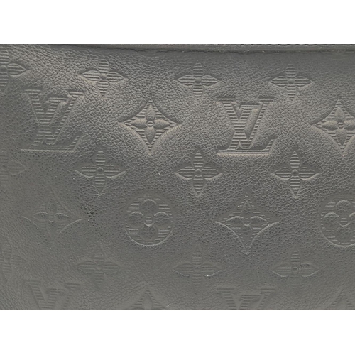 89 - A Louis Vuitton Black Gaston Wearable Wallet. Monogram coated canvas exterior with black-toned hardw... 