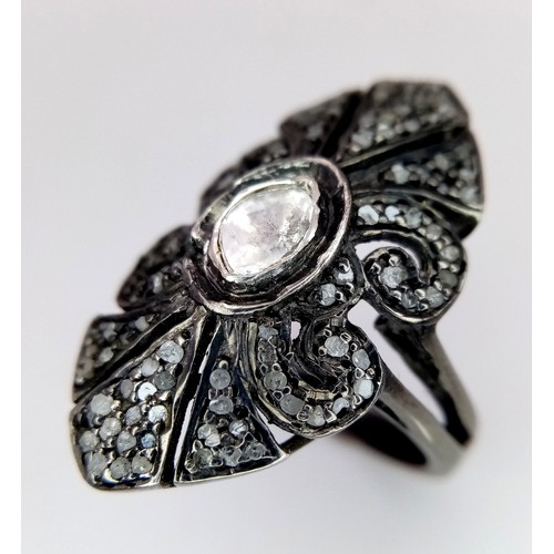 139 - An antique ARTS & CRAFTS sterling silver ring with a shield design adored with a central old cut dia... 