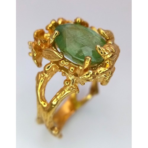 167 - A silver and gold ring with an oval cut central green stone (beryl?) in a unique naturalistic design... 