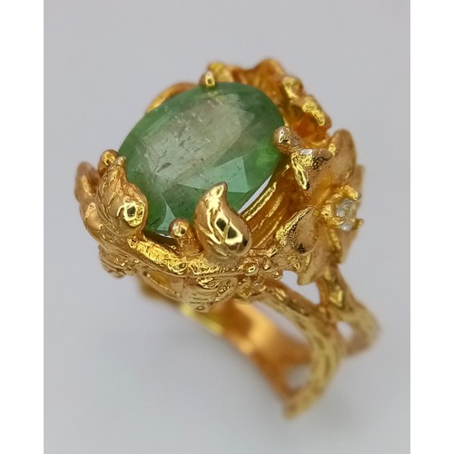 167 - A silver and gold ring with an oval cut central green stone (beryl?) in a unique naturalistic design... 