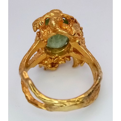 167 - A silver and gold ring with an oval cut central green stone (beryl?) in a unique naturalistic design... 