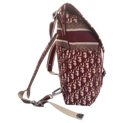 122 - A Christian Dior Burgundy Oblique Backpack. Monogram textile exterior with silver-toned hardware, ha... 