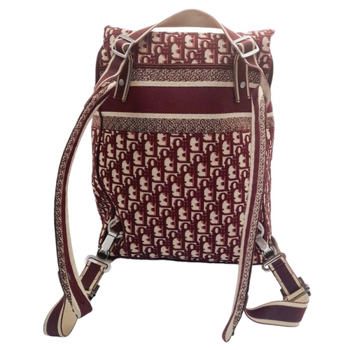 122 - A Christian Dior Burgundy Oblique Backpack. Monogram textile exterior with silver-toned hardware, ha... 