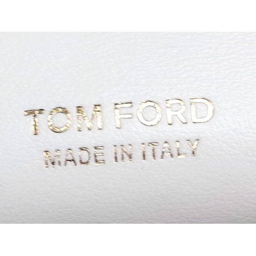 143 - A Tom Ford White Bianca Bag. Leather exterior with gold-toned hardware, handle and magnetic closure.... 