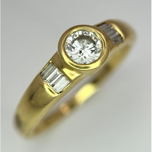 1096 - An 18K Yellow Gold Diamond Ring. 0.33ct central diamond with small baguette diamonds on shoulders. S... 