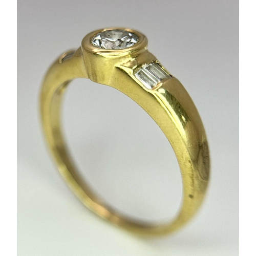 1096 - An 18K Yellow Gold Diamond Ring. 0.33ct central diamond with small baguette diamonds on shoulders. S... 