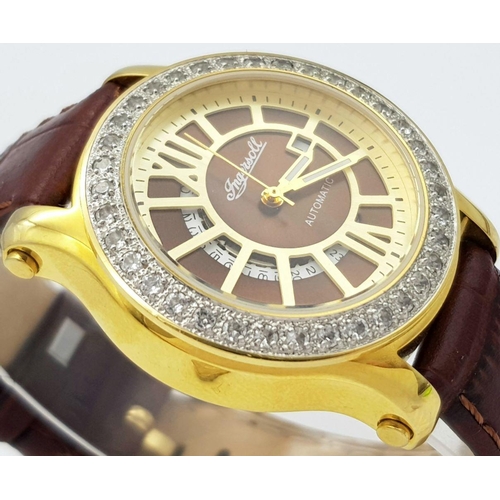 727 - An Ingersoll Automatic Stone Set Ladies Watch. Brown leather strap. Gilded stone set case - 34mm. Br... 