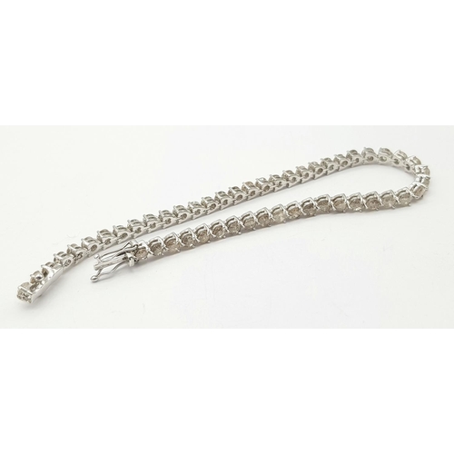 47 - An 18 K white gold tennis bracelet with round cut diamonds (6 carats appr.) Length: 18.5 cm, weight:... 