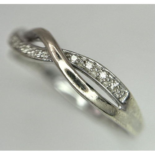 692 - A 9K WHITE GOLD DIAMOND SET TWIST CELTIC DESIGN RING. 1.9G. SIZE O. REF: SPAS 5006