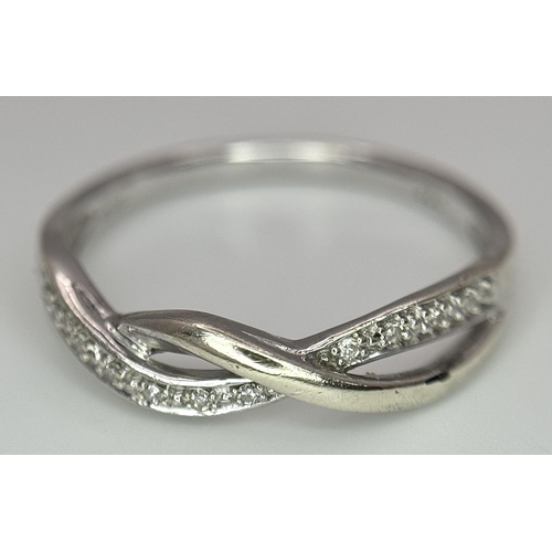 692 - A 9K WHITE GOLD DIAMOND SET TWIST CELTIC DESIGN RING. 1.9G. SIZE O. REF: SPAS 5006