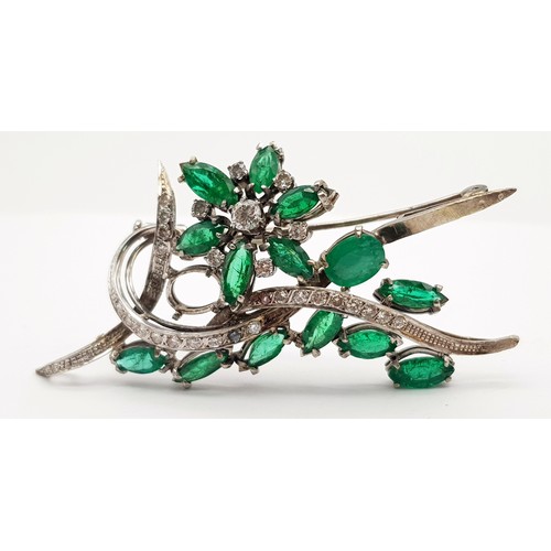 40 - An 18 K white gold brooch with a floral motif carrying oval and marquise cut emeralds  (5.5 carats a... 