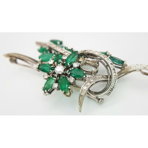 40 - An 18 K white gold brooch with a floral motif carrying oval and marquise cut emeralds  (5.5 carats a... 