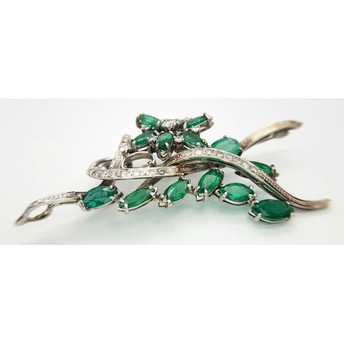 40 - An 18 K white gold brooch with a floral motif carrying oval and marquise cut emeralds  (5.5 carats a... 