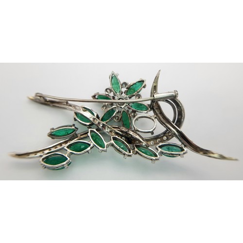 40 - An 18 K white gold brooch with a floral motif carrying oval and marquise cut emeralds  (5.5 carats a... 