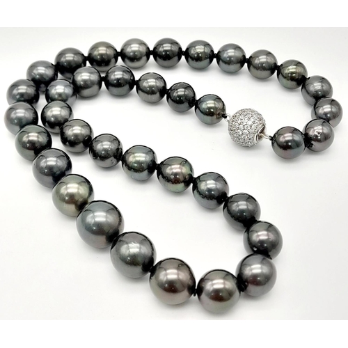 834 - A dark grey pearl necklace, graduating 10-13 mm natural spherical pearls with a glamorous diamante c... 