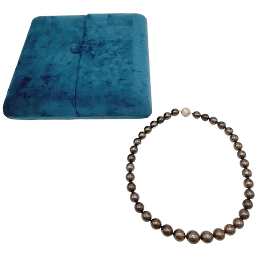 834 - A dark grey pearl necklace, graduating 10-13 mm natural spherical pearls with a glamorous diamante c... 