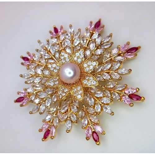 835 - An AKOYA brooch in original inner and outer box. The central  spherical pearl is surrounded by cubic... 