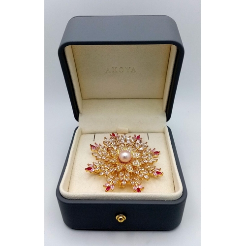 835 - An AKOYA brooch in original inner and outer box. The central  spherical pearl is surrounded by cubic... 