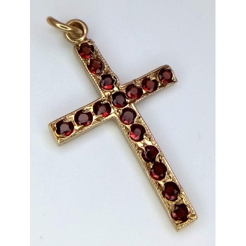 1120 - A 9K YELLOW GOLD RED STONE SET CROSS. 0.55G IN WEIGHT. Ref: SC 5067.