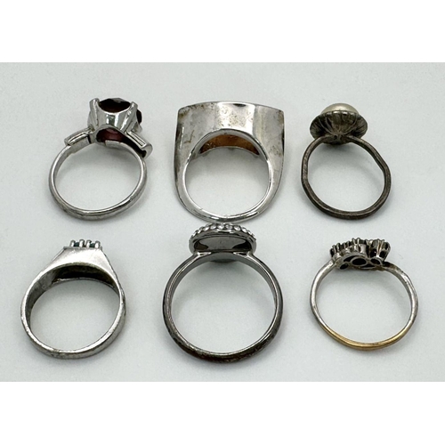 890 - An interesting group of six rings -some silver examples- with a variety of gems. Total weight: 25.6 ... 