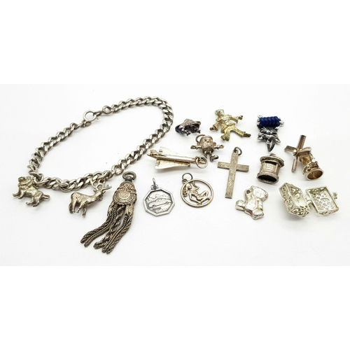 892 - A sterling silver chain bracelet and a total of fifteen charms including a post box, a teddy bear, a... 