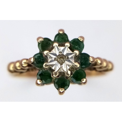 905 - A vintage 9 K yellow gold ring with a small diamond surrounded by eight round cut emeralds. Size: O1... 