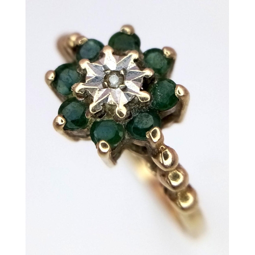 905 - A vintage 9 K yellow gold ring with a small diamond surrounded by eight round cut emeralds. Size: O1... 