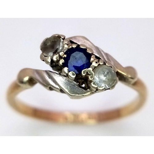 906 - A vintage 9 K yellow gold ring with a round cut blue sapphire  accompanied by two round cut diamonds... 