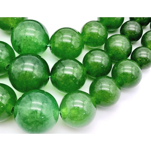 975 - A Chinese Three Row Graduating Green Jade Bead Necklace. Largest beads -14mm. 44-46cm