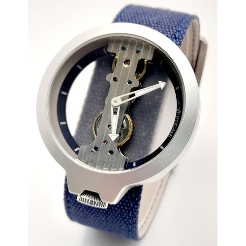 1016 - A Verticale Mechanical Top Winder Gents Watch. Blue textile strap. Ceramic silver tone skeleton case... 