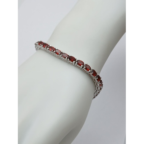 562 - An Almandine Garnet Tennis Bracelet on 925 Silver. 32ctw. 19cm length, 21g total weight. Comes in pr... 