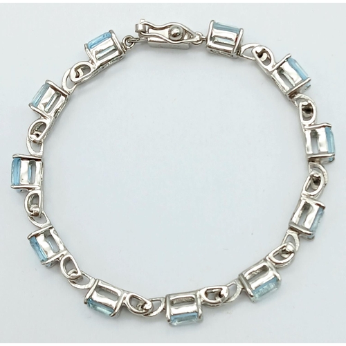 800 - A Rectangular Step Cut Blue Topaz Tennis Bracelet. On 925 silver. 28ctw. 18cm length, 17.4g total we... 