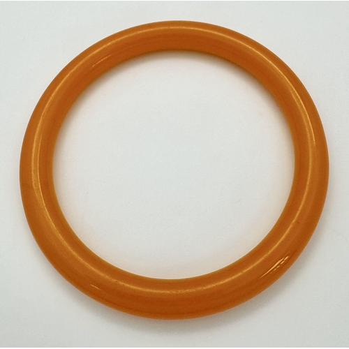 873 - A Colourful Orange Jade Thin Bangle. 9mm width. 6cm inner diameter.