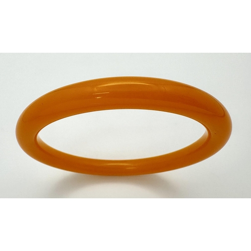 873 - A Colourful Orange Jade Thin Bangle. 9mm width. 6cm inner diameter.