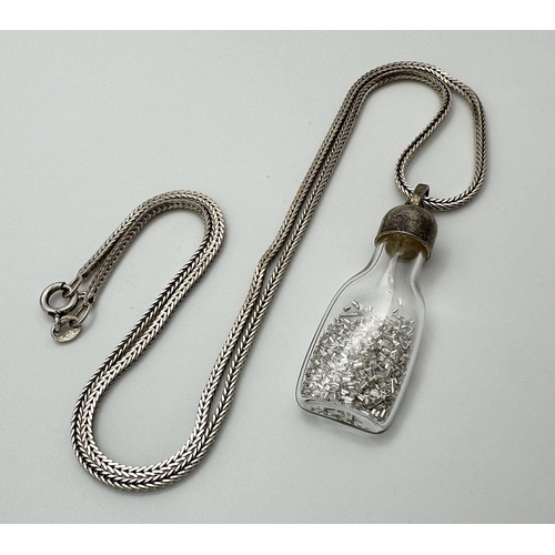 773 - A 44cns SILVER CHAIN WITH A SILVER TOPPED GLASS BOTTLE PENDANT CONTAINING SILVER METAL SHAVINGS .   ... 