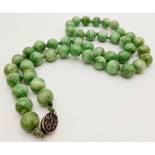 569 - An Antique Jade Necklace with Silver Clasp. 12mm diameter beads, 64.5cm length, 134g total weight.