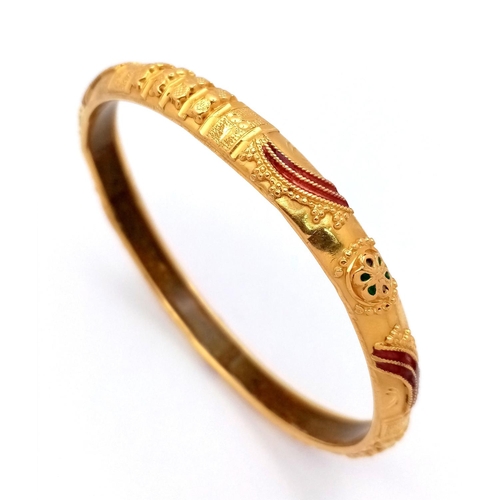 967 - An Asian Inspired 22k Yellow Gold Bangle. Emerald and ruby decoration. Silicone liner. 15.75g total ... 