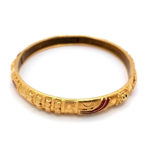 967 - An Asian Inspired 22k Yellow Gold Bangle. Emerald and ruby decoration. Silicone liner. 15.75g total ... 