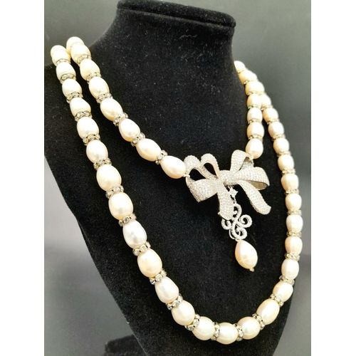 105 - A very glamorous two string cultured pearl necklace with a show stopping bow, loaded with cubic zirc... 