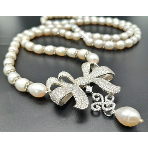 105 - A very glamorous two string cultured pearl necklace with a show stopping bow, loaded with cubic zirc... 