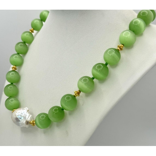 389 - A Hypnotic Green Opal Cat's Eye Necklace with a Baroque Pearl Interrupter. Large 14mm beads. Gilded ... 