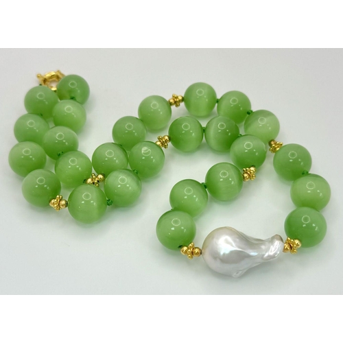 389 - A Hypnotic Green Opal Cat's Eye Necklace with a Baroque Pearl Interrupter. Large 14mm beads. Gilded ... 