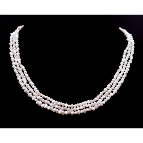 1478 - A Three Row Petit Rice Pearl Necklace with 9k Gold Clasp. 40cm.