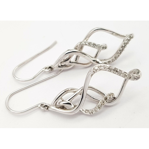 446 - A PAIR OF 9K WHITE GOLD DIAMOND SET SWIRL DESIGN DROP EARRINGS 4.4G TOTAL WEIGHT, 2.5CM LENGTH.

ref... 