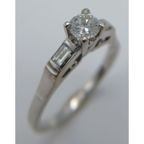 47 - AN 18K WHITE GOLD DIAMOND SOLITAIRE WITH BAGUETTE SET SHOULDERS RING 0.35CT MAIN ROUND STONE PLUS 0.... 